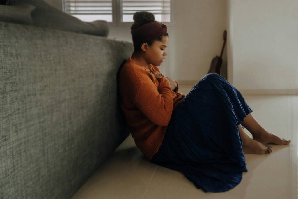 Mujer sentada junto al sofá con ansiedad